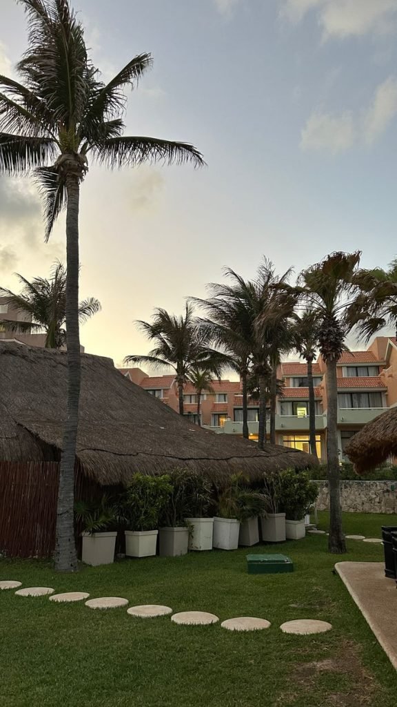Peaceful tropical landscape with palm trees and resort at sunset in Cancún, Mexico.